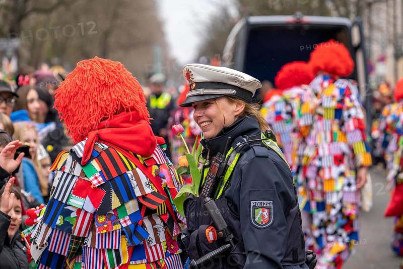 Rose Monday parade in Düsseldorf, policemen on duty at the street carnival, with flower decorations, given by the parade participants, North Rhine-Westphalia, Germany, Europe