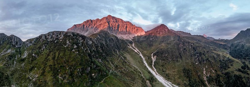 Panorama, rocky mountain peak Porze and green mountain landscape with river valley at sunrise, alpenglow, Carnic High Trail, Carnic Alps, Carinthia, Austria, Europe