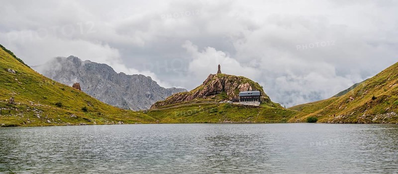 View over the Wolayersee lake to Alpenvereinshütte Wolayerseehütte, cloudy mountain landscape, Carnic Alps, Carnic High Trail, Carinthia, Austria, Europe