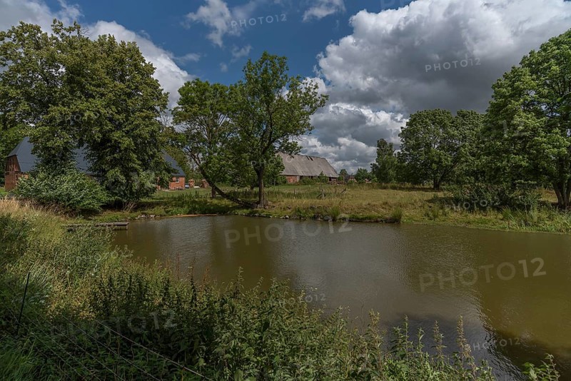 Manor house from 1920, in front the fire pond, in the back former horse stable and large barn, Othenstorf, Mecklenburg-Vorpommern, Germany, Europe