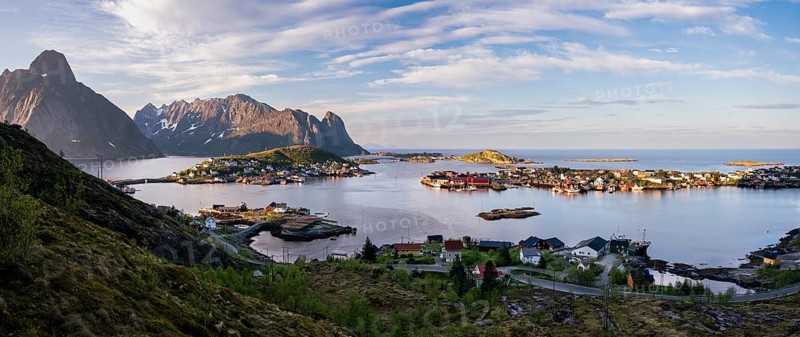 Panorama, landscape seen from Lake Reinevatnet. View of the town of Reine and Gravdalsbukta (Gravdals Bay), with the mountains Olstinden and Lilandstinden on the left. Late in the evening at the time of the midnight sun in good weather. Early summer. Reine, Moskenesoya, Lofoten, Norway, Europe