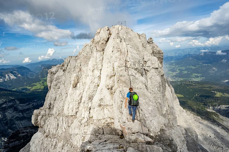 Mountaineer on a narrow rocky ridge on a steel cable, Watzmann crossing to Watzmann Mittelspitze, view of mountain panorama, Berchtesgaden National Park, Berchtesgaden Alps, Bavaria, Germany, Europe