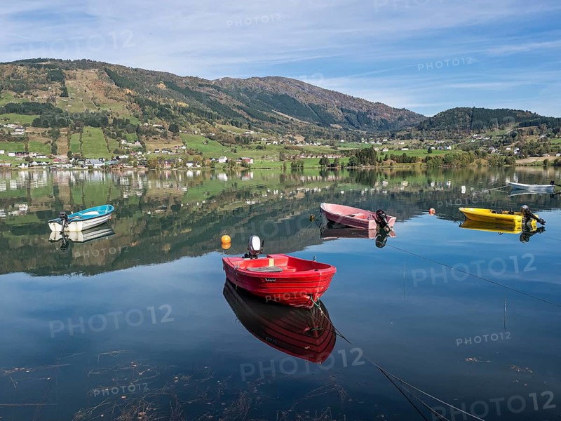 Boats on the calm lake Hafslovatnet, mountains reflected in the lake, Sognefjord region, Norway, Europe