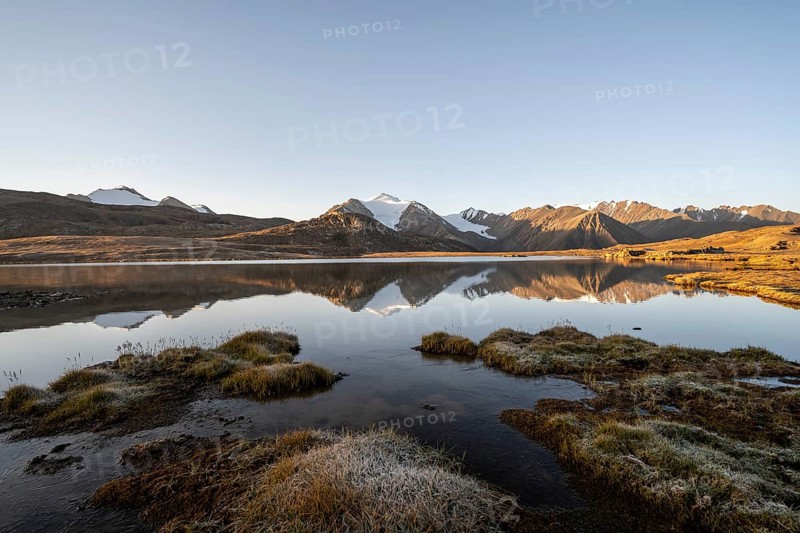Glaciated mountain peaks reflected in a mountain lake at sunset, Arabel Lake at Arabel Pass, Issyk Kul Province, Kyrgyzstan, Asia