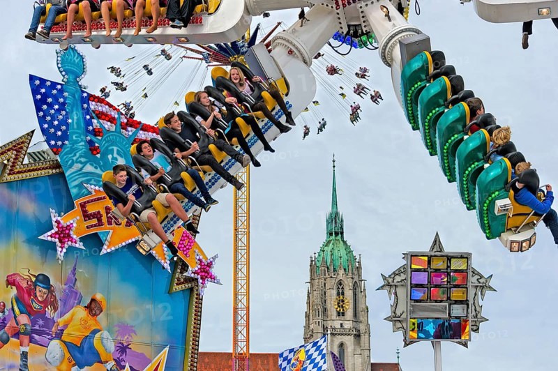 People whirling in carousel skater, ride on the Wies'n, Oktoberfest, Wiesn, behind parish church St. Paul, Paulskirche, Munich, Upper Bavaria, Bavaria, Germany, Europe