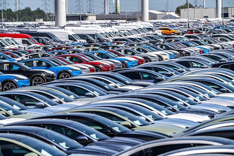 Storage area for new cars in the port of Vlissingen-Oost, vehicles are temporarily stored on over 100 hectares to ship them from Europe to the United Kingdom, Ford cars, others such as models from the Chinese car manufacturer BYD are delivered from here in Europe, wind farm, Netherlands