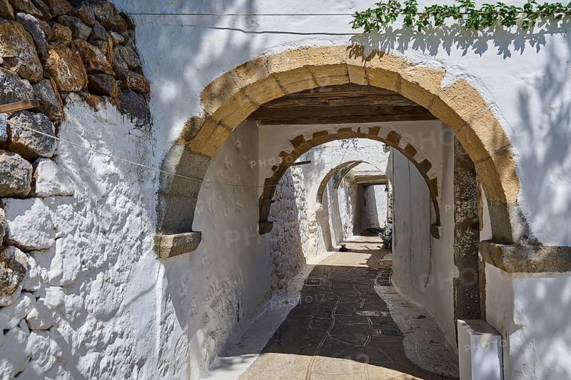 Narrow, vaulted passageway with stone arches and white-painted walls in a quiet, historic neighbourhood, Chora, Old Town, Patmos, Dodecanese, Greek Islands, Greece, Europe