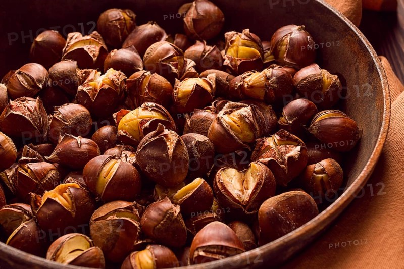 Roasted chestnuts, in an iron pan, wooden table, top view, no people, rustic style