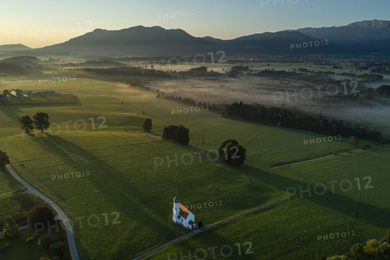 Aerial view of a chapel in front of mountains, morning light, Sankt Johannisrain, view of Zwiesel and Benediktenwand, Alpine foothills, Bavaria, Germany, Europe