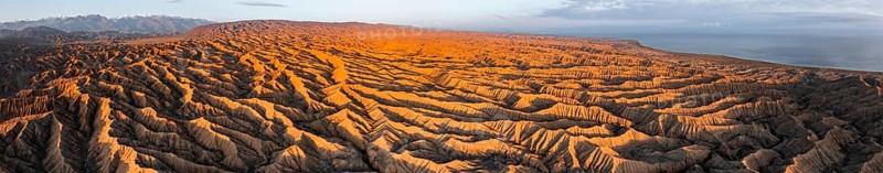 Panorama, landscape of eroded hills, badlands at sunset, Lake Issyk Kul in the background, aerial view, Canyon of the Forgotten Rivers, Issyk Kul, Kyrgyzstan, Asia