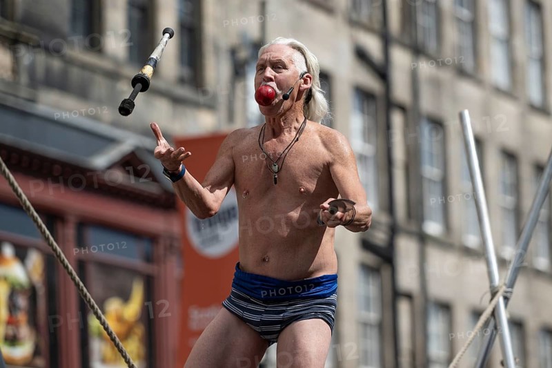 Street performer balancing while eating apple, high wire acrobatic performance, world's largest cultural festival The Fringe, High Street, Edinburgh, Scotland, United Kingdom, United Kingdom, Europe