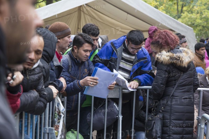 Refugees from Syria wait behind barriers in the Central Reception Centre for Asylum Seekers at the Berlin State Office for Health and Social Affairs for their registration, 09.10.2015