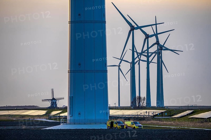 Windmill Poldermolen De Goliath stands between the high-tech wind turbines in Eemshaven, historic windmill from around 1882, rebuilt and reconstructed several times, Westereems wind farm, solar farm on sea dike, Slaperdijk, a good 5 kilometres long, Netherlands