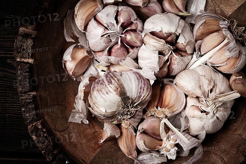 Fresh garlic, in a wooden plate, top view, close-up, no people