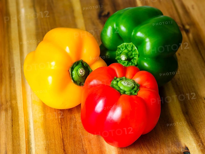 Close-up, yellow, red, green peppers (Capsicum annuum) on wooden board