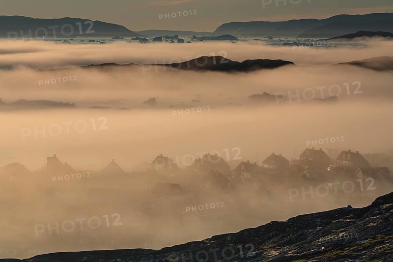 Houses in the fog in front of icebergs and ice floes, summer, midnight sun, Jakobshavn glacier and ice fjord, Ilulissat, Disko Bay, West Greenland, Greenland, North America