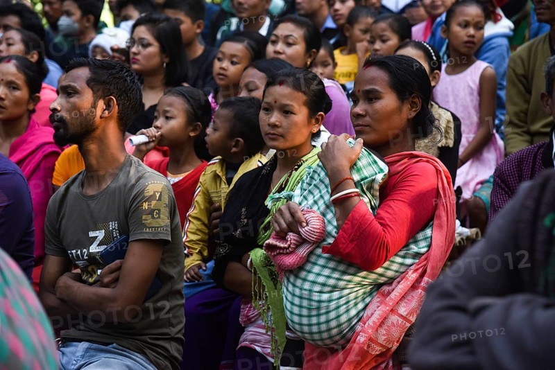 People enjoying a drama during 'Under The Sal Tree' Theatre Festival on December 15, 2021 in Goalpara, Assam, India. Under the Sal Tree theatre festival is one of its kind, held at Badungduppa Kala Kendra in the middle of a dense Sal forest in rural Lower Assam. The festival was started by Sukracharjya Rabha, a widely respected theatre personality of Assam, in 2008. He wanted to spread a message of coexistence with nature and made in a completely natural setting inside a jungle, which made the theatre festival unique
