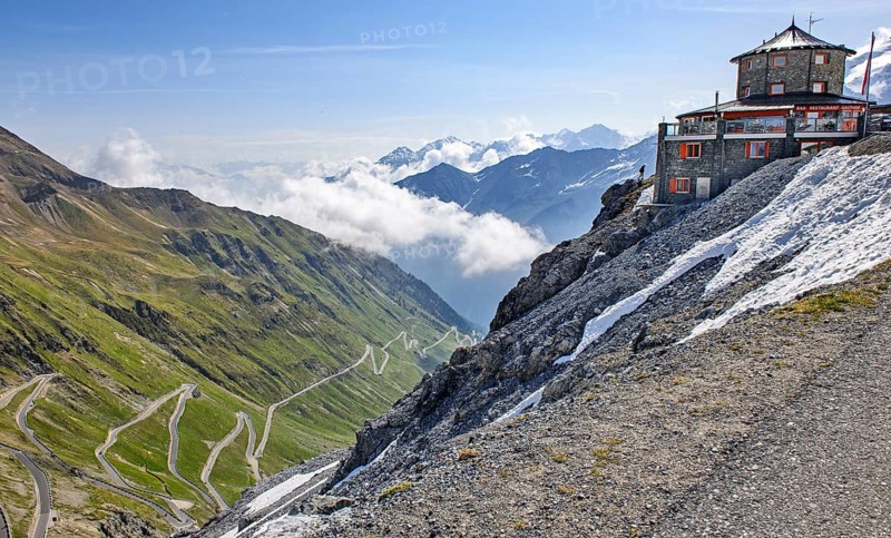 Right historic mountain hotel Hotel Restaurant Bar Gasthof Alpengasthof in Tibetan style Tibetan house at 2800 metres above sea level in the background 2757 2758 metres high pass high pass summit from left east ramp north ramp to Alpine pass Alpine road Pass road with serpentines tight bends Stelvio Pass Stelvio, Stelvio, South Tyrol, Alto Adige, Italy, Europe