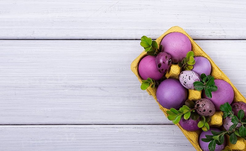 Easter eggs, purple and lilac, on a white wooden table, Easter card, banner, selective focus, horizontal