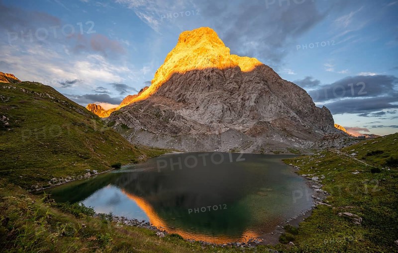Alpenglow at Seekopf or Monte Capolago, reflection in Wolayersee, mountain landscape with green meadows and mountain lake at sunset, Carnic Alps, Carnic High Trail, Carinthia, Austria, Europe