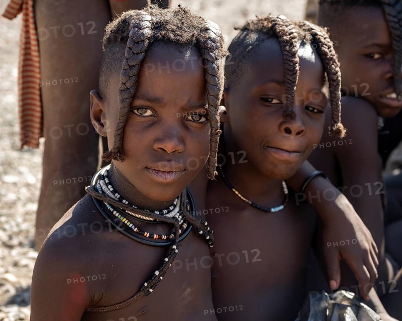Two Himba girls with braids braided to the front, arm in arm, near Opuwo, Kaokoveld, Kunene, Namibia, Africa