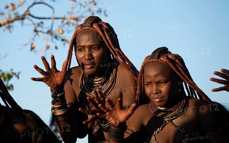 Traditional Himba woman clapping, music and dance, portraits, in the evening light, near Opuwo, Kaokoveld, Kunene, Namibia, Africa