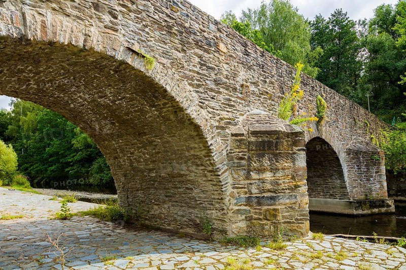 Old Mulde Bridge Stone Bridge Built in 1501 Next to the normal village road, hikers and cyclists will find a historic stone bridge. The old Mulde bridge next to the concrete bridge was built in 1501. It replaced the wooden footbridge of the oldest Dresden country road, Halsbrücke, Conradsdorf, Saxony, Germany, Europe