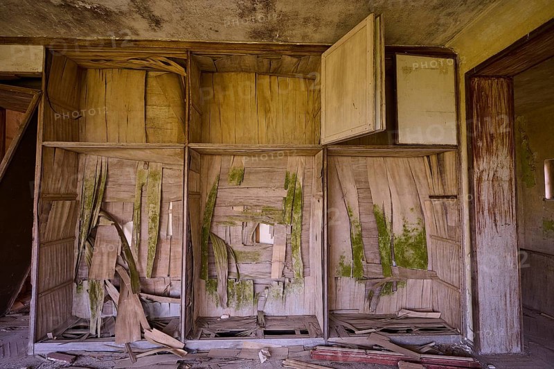 Dilapidated room with damaged wooden furniture and shelves, showing clear signs of decay and dirt on the walls, Mussolini Villa, Villa de Vecchi, Profitis Ilias, Empona, Rhodes, Dodecanese, Greek Islands, Greece, Europe