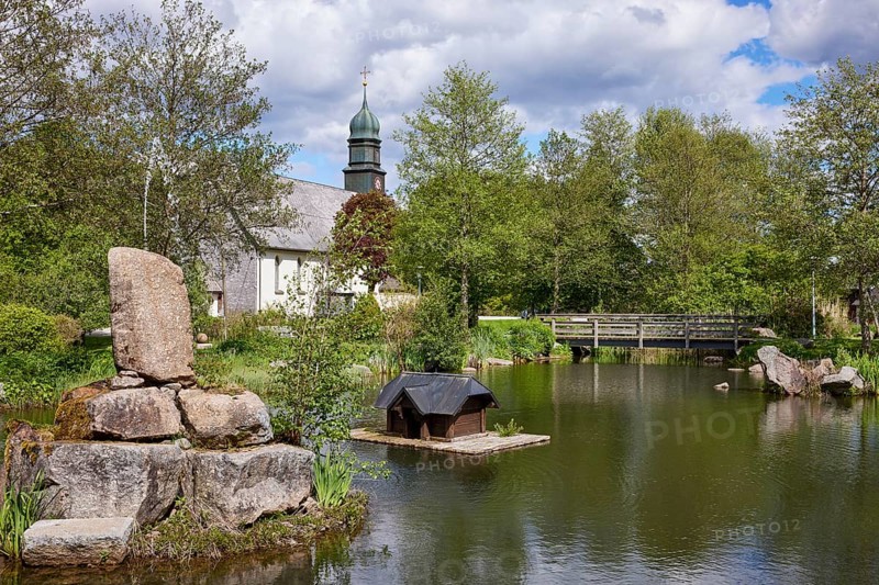 Spa gardens with pond and wooden bridge and St Johann's Church in the Innerlehen district, Bernau im Black Forest, Black Forest, Waldshut district, Baden-Württemberg, Germany, Europe