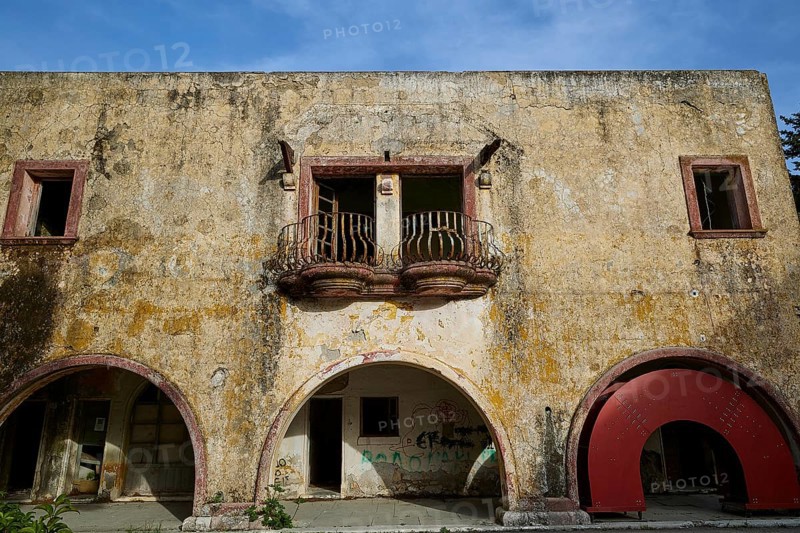 The dilapidated façade of a historic building with a yellow wall, several windows and decorative balconies, Italian Governor's Palace, Ruins, Italian colonial settlement, Eleousa, Rhodes, Dodecanese, Greek Islands, Greece, Europe