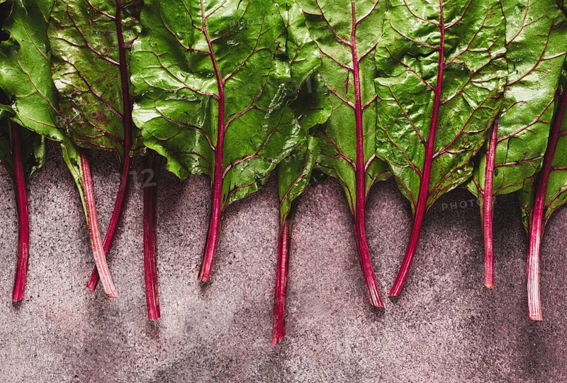 Fresh, green leaves, stem with beet leaves, on the table, top view, rustic, no people