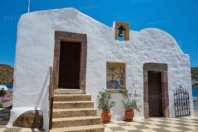 White building in traditional Greek style with staircase, two doors and bell, under blue sky and in mountain landscape, Baptistery, St John the Theologian, Skala, Patmos, Dodecanese, Greek Islands, Greece, Europe
