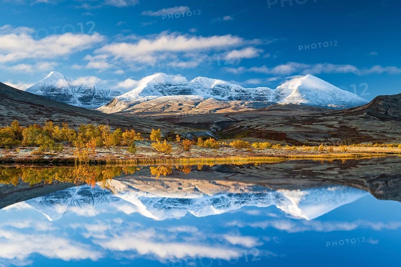 Reflection of the autumn landscape in Rondane National Park, snow-capped mountains, Doraldalen, Norway, Europe