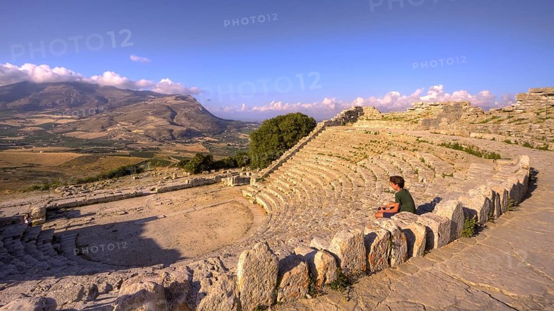 Evening light, Roman amphitheatre, sitting boy from the side, Segesta, Ancient site, Archaeological site, Doric, Trapani province, Sicily, Italy, Europe