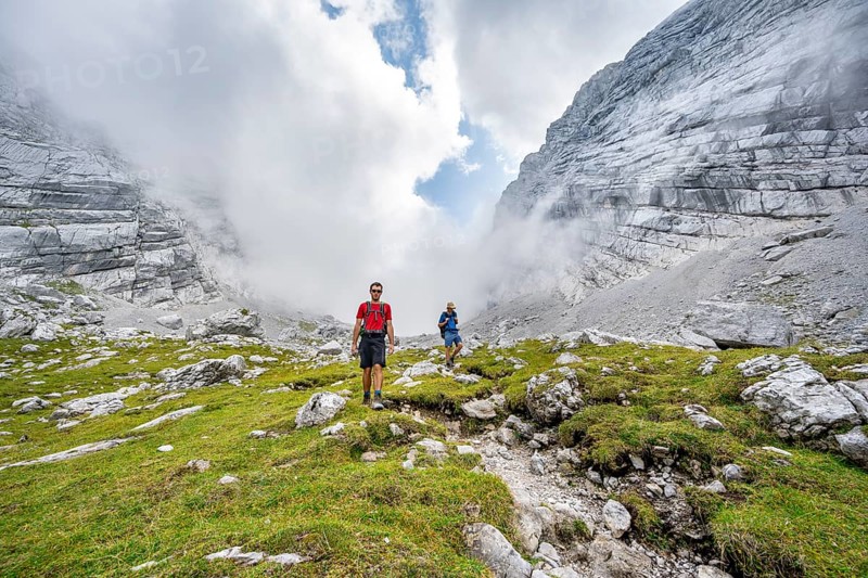 Two mountaineers on a hiking trail, cloudy mountain basin, descent via the Ofental valley, mountain tour on the Hochkalter, Hochkalter crossing, Berchtesgaden Alps, Bavaria, Germany, Europe