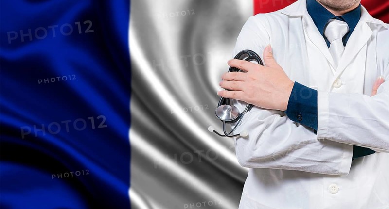 Doctor with stethoscope on French flag. Doctor with arms crossed on French flag background. Medical health and care on French flag