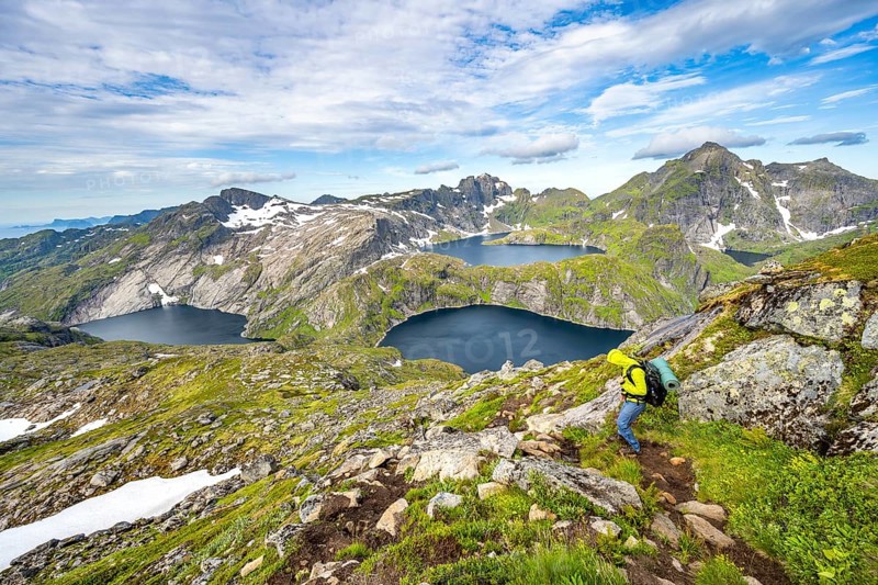 Mountaineers on a hiking trail, mountain landscape with steep rocky mountain peaks and lake Tennesvatnet, Krokvatnet and Fjerddalsvatnet, in the back peak of Hermannsdalstinden, view from the top of Munken, Moskenesoya, Lofoten, Nordland, Norway, Europe