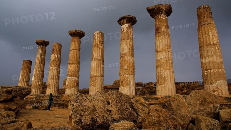 Row of columns, chapter, Heracles temple, dark clouds, sun, thunderstorm atmosphere. Valley of the temples, valle dei templi, Agrigento, Sicily, Italy, Europe