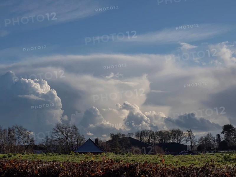Dramatic clouds over Sussex on a Winter's late afternoon, with farm buildings and trees in foreground
