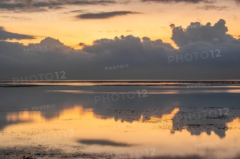 Beautiful seascape in the morning. Tropical sandy beach with breakwater and reflection of the sky in the calm water. Morning landscape, taken in Sanur, Bali, Indonesia, Asia