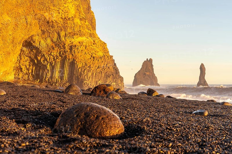 Beautiful on the black sand beach of Reynisfjara at sunset in Iceland