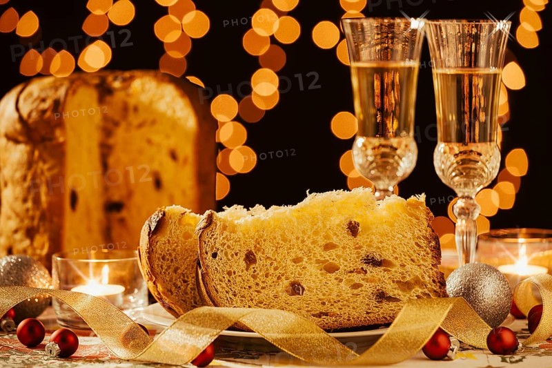 Sliced italian panettone and sparkling wine with decorations