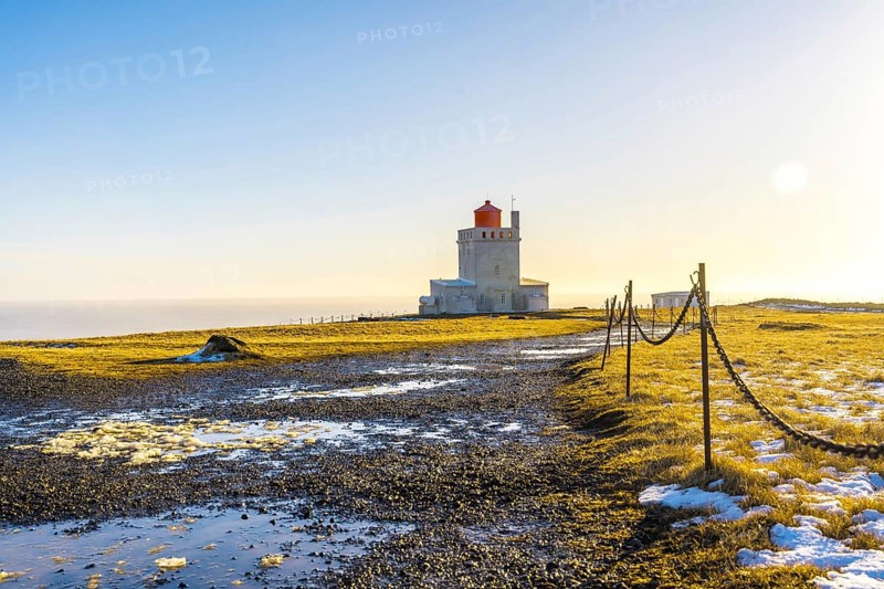 Trail leading to the famous lighthouse at sunset on Dyrholaey beach in Iceland in the cold winter, near Vik