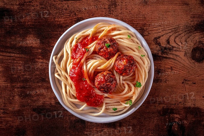 Meatballs. Beef meat balls, overhead shot with spaghetti pasta, parsley, and tomato sauce, on a rustic wooden background, Food photography