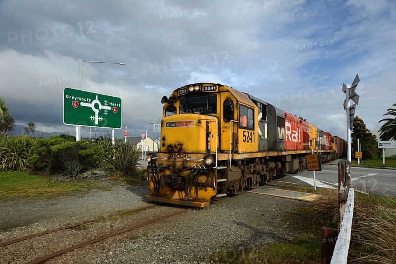 HOKITIKA, NEW ZEALAND, AUGUST 29, 2020: A freight train crosses the main street of Hokitika near the roundabout on State Highway 6