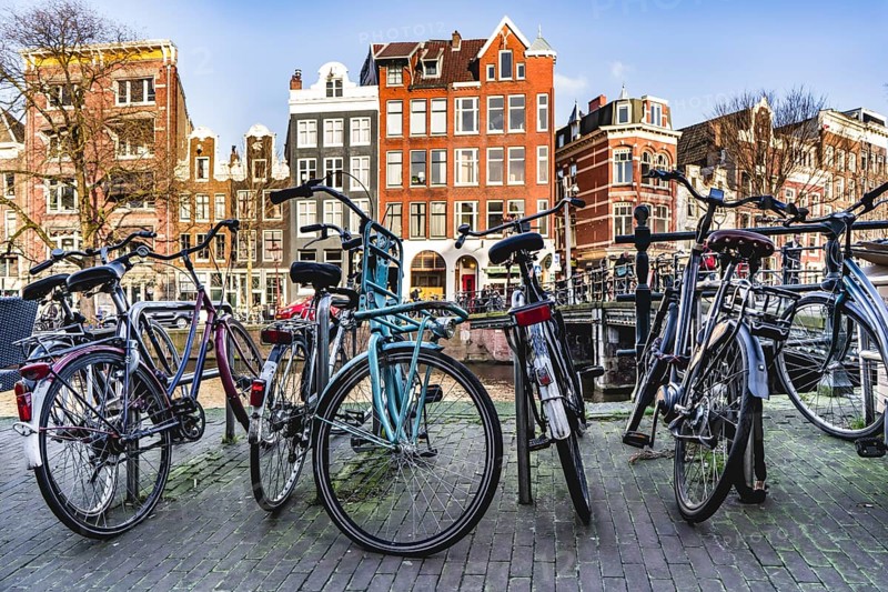Bicycles parked near a canal in Amsterdam city