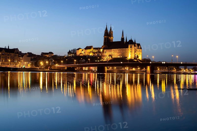 The Elbe in Meissen is slightly high water after the snow has melted, the Burgberg is reflected in the river at blue hour