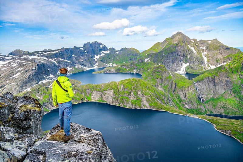 Mountaineers at the summit of Munken, mountain landscape with steep rocky mountain peaks and lakes Tennesvatnet and Krokvatnet, in the back summit of Hermannsdalstinden, Moskenesoya, Lofoten, Nordland, Norway, Europe