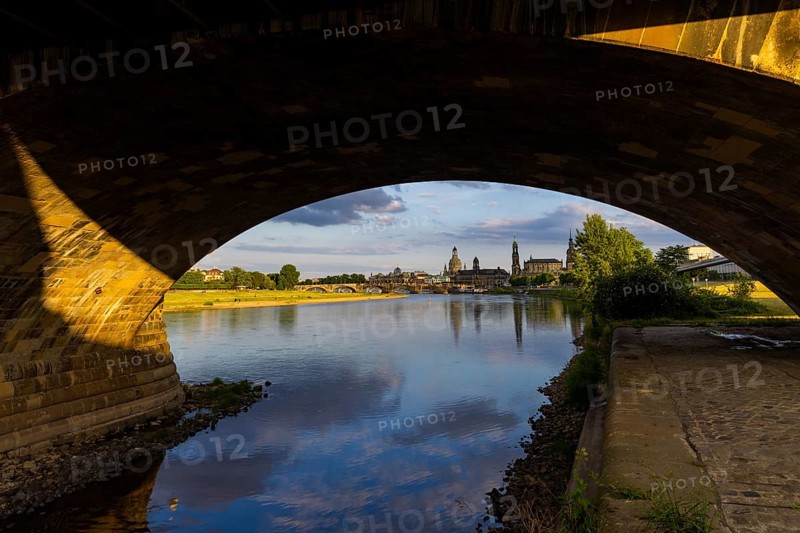View through the arches of the Marienbrücke onto the Elbe meadows in Dresden's Old Town with silhouette