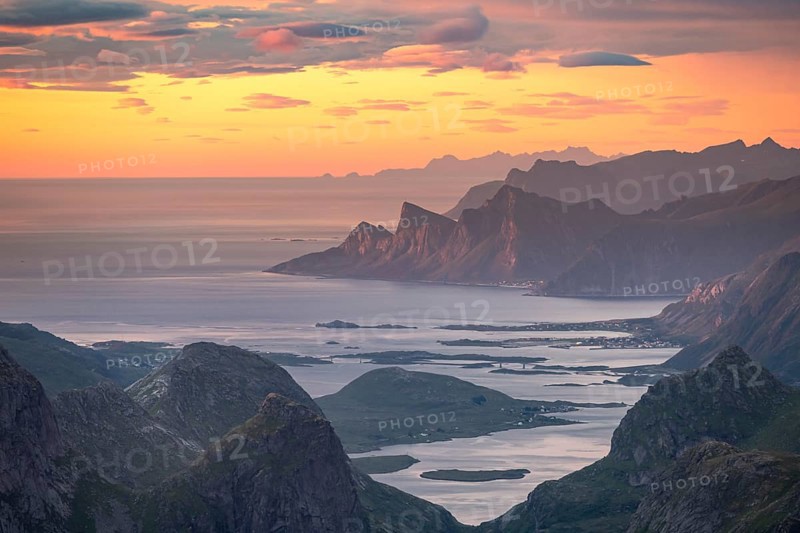 View over mountain top and sea to Fredvang, dramatic sunset, from the top of Hermannsdalstinden, Moskenesöy, Lofoten, Nordland, Norway, Europe